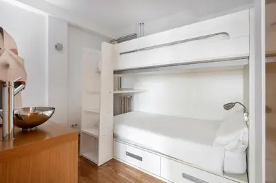 a bedroom with white bunk beds and a desk at La Mejor Zona de Barcelona in Barcelona