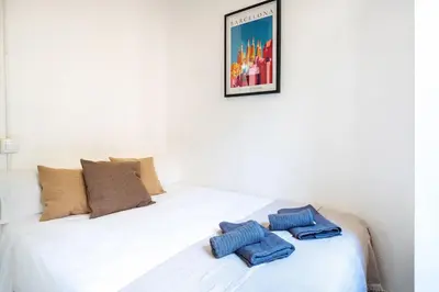a white bed with two blue towels on it at Centric Apartments Sagrada Famila 3 in Barcelona