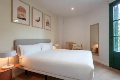 a bedroom with a white bed and a green door at CATERINA Sant Pau in Barcelona