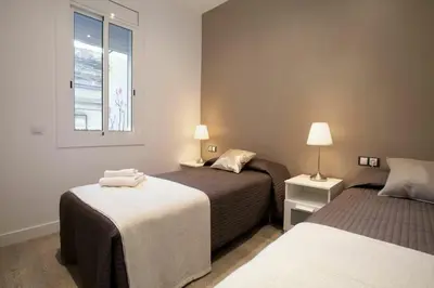 a bedroom with two beds and a window at Bed&BCN Enamorats in Barcelona