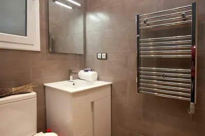 a bathroom with a sink and a toilet and a mirror at Bed&BCN Enamorats in Barcelona