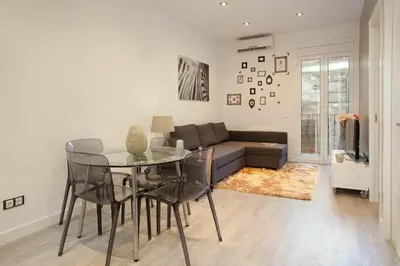 a living room with a table and a couch at Bed&BCN Enamorats in Barcelona