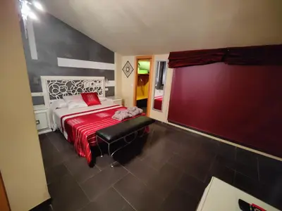 a bedroom with a large bed with a red blanket at Hostal Manel in Pineda de Mar