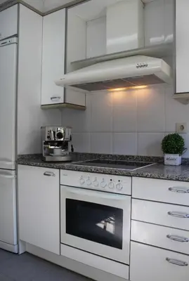 a kitchen with white cabinets and a stove top oven at Barcelo al riu in Monistrol
