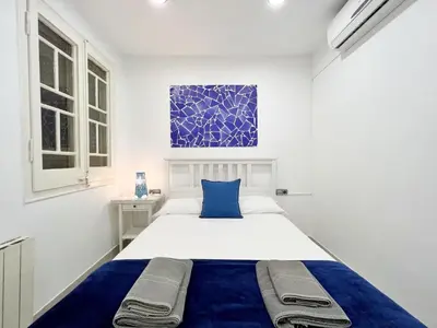 a white bedroom with a blue and white bed at Sagrada Familia Gaudi in Barcelona