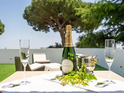 a bottle of wine sitting on a table with two glasses at Luxury Villa Buena Vista Pool and Garden in Arenys de Munt