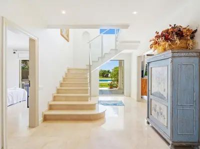 a living room with stairs and a blue cabinet at Luxury Villa Buena Vista Pool and Garden in Arenys de Munt