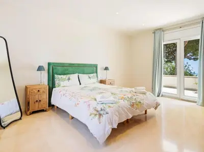 a white bedroom with a bed and a window at Luxury Villa Buena Vista Pool and Garden in Arenys de Munt