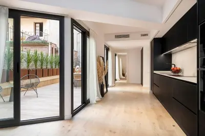 a kitchen with black cabinets and a hallway with sliding glass doors at Luxury apartment in Barcelona City Center in Barcelona