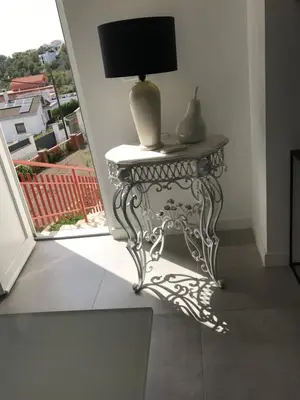 a table with a lamp on it next to a window at Campagne luxueuse de Sitges in Olivella