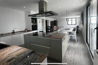 a kitchen with a counter and a table in it at Villa Oasis entre Viñedos cerca de Barcelona con A A y piscina climatizada in Caserío de Caʼn Rosell