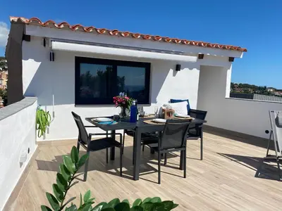 a patio with a table and chairs on a balcony at Ses Voltes Boutique Home Sea and Sky in Vilassar de Dalt