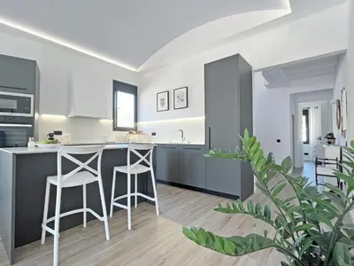 a kitchen with a counter and stools in a room at Ses Voltes Boutique Home Sea and Sky in Vilassar de Dalt