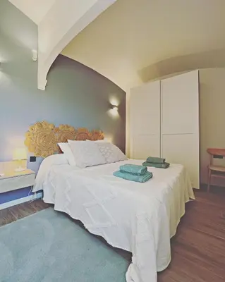 a bedroom with a large white bed with towels on it at Ses Voltes Boutique Home Sea and Sky in Vilassar de Dalt