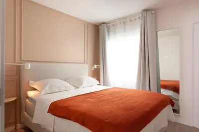 a bedroom with a large bed with an orange blanket at Rambla Suites in Barcelona