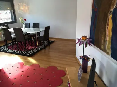 a dining room with a table and a red heart rug at New & Sunny Apartment in Barcelona