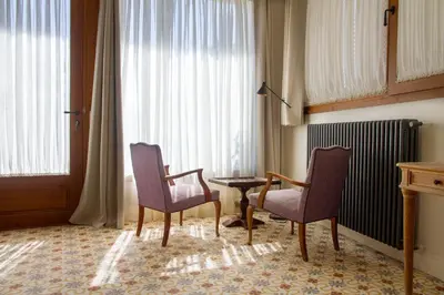 a room with two chairs and a table and a window at Bell Plançó B&B in Moià