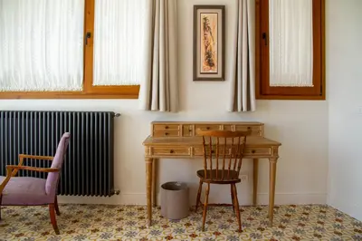 a desk and two chairs next to a radiator at Bell Plançó B&B in Moià