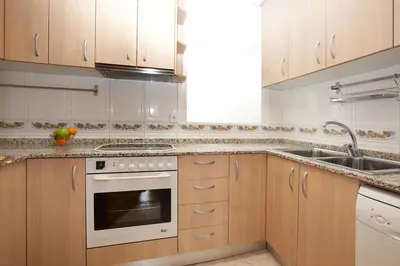 a kitchen with wooden cabinets and a stove and sink at LetsGo Sagrada Familia Penthouse in Barcelona