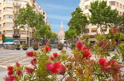 a city street with pink flowers and buildings at LetsGo Sagrada Familia Penthouse in Barcelona