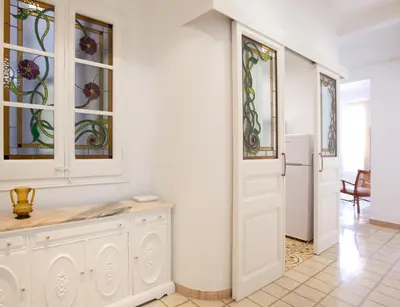 a white room with a white door and stained glass windows at Casa Muntaner in Barcelona