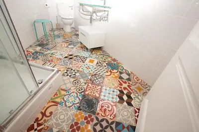 a bathroom with a tile floor with a toilet at Casa Muntaner in Barcelona