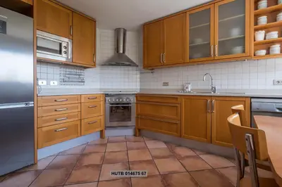 a kitchen with wooden cabinets and a stainless steel refrigerator at Alcam Vila Olímpica in Barcelona