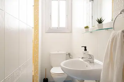 a white bathroom with a toilet and a sink at APARTMENT BEACH PICASSO in Sant Adria de Besos