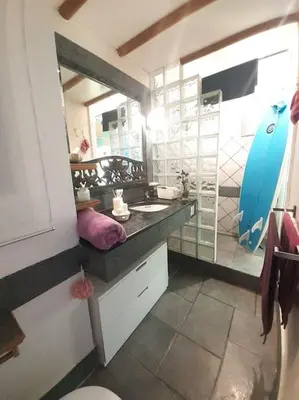a bathroom with a sink and a surfboard in it at Maresme´s corner in Sant Andreu de Llavaneres
