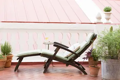 a green chair sitting on a patio with a table at The Patio Barcelona in Barcelona