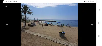a beach with people and umbrellas and the ocean at Caldetas in Caldes d'Estrac