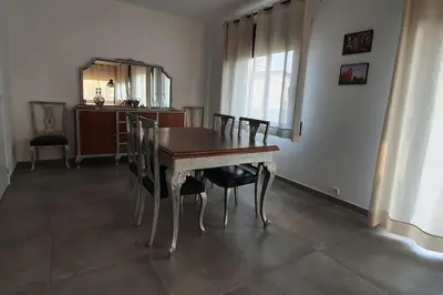 a dining room with a wooden table and chairs at CASA CENTRO DEL PUEBLO CON PISCINA PRIVADA in Sant Vicenç de Montalt