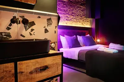 a bedroom with a bed with purple lighting at Dormsy Pension Boutique in Arenys de Mar