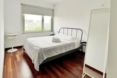 a white bedroom with a bed and a window at Ral48 in Sant Adria de Besos