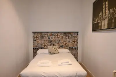 a small room with a bed with two towels at Homenfun Barcelona Vallcarca in Barcelona