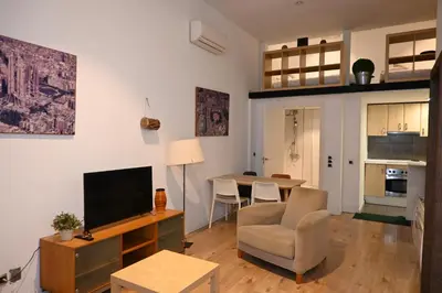 a living room with a television and a dining room at Homenfun Barcelona Vallcarca in Barcelona