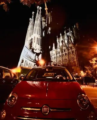 a red car parked in front of a large building at Loft nearby Sagrada Familia in Barcelona