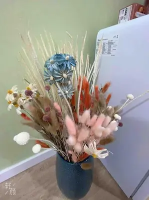 a blue vase with flowers in it next to a refrigerator at Loft nearby Sagrada Familia in Barcelona