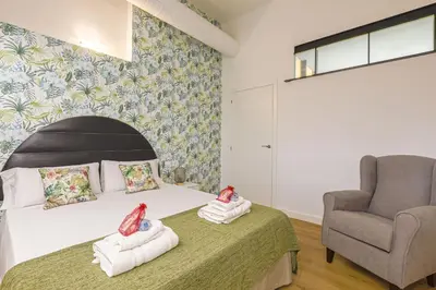 a bedroom with a bed and a chair at Alcam Les Corts in Barcelona