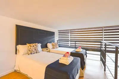 a bedroom with two beds and a balcony at Alcam Les Corts in Barcelona