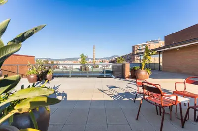 a patio with chairs and tables on a roof at Hotel Terrassa Confort in Terrassa