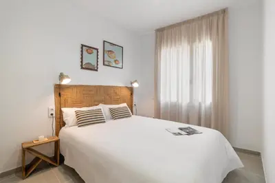 a bedroom with a large white bed and a window at Calella Apartments by Olala Homes in Calella