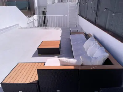 a bench on a balcony with pillows on it at Mazi Apartments Cuba in Mataró