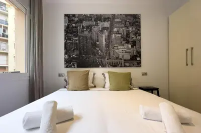 a bedroom with a large white bed with two towels at Sagrada Familia Bliss in Barcelona