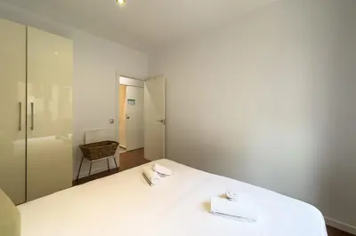 a bedroom with a white bed with a mirror at Sagrada Familia Bliss in Barcelona