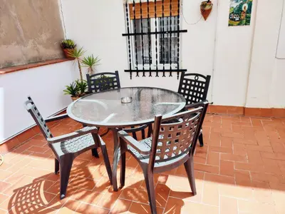 a glass table and chairs on a patio at Amplio apartamento con terraza in Hospitalet de Llobregat