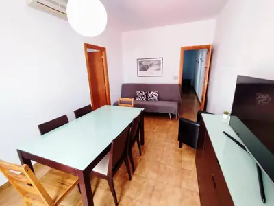 a living room with a table and a couch at Amplio apartamento con terraza in Hospitalet de Llobregat