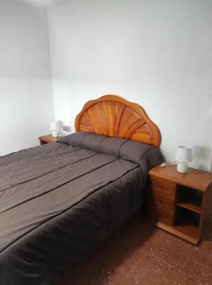 a bedroom with a large bed and two night stands at Apartamentos Can Bruguera 4 in Mataró