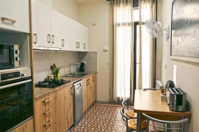 a kitchen with wooden cabinets and a counter top at La LLar de la Kim, Bonita casa a 150m del mar y 40km de Barcelona in Arenys de Mar