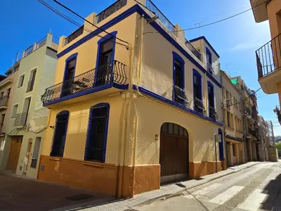 a yellow building with a door and a balcony at La LLar de la Kim, Bonita casa a 150m del mar y 40km de Barcelona in Arenys de Mar